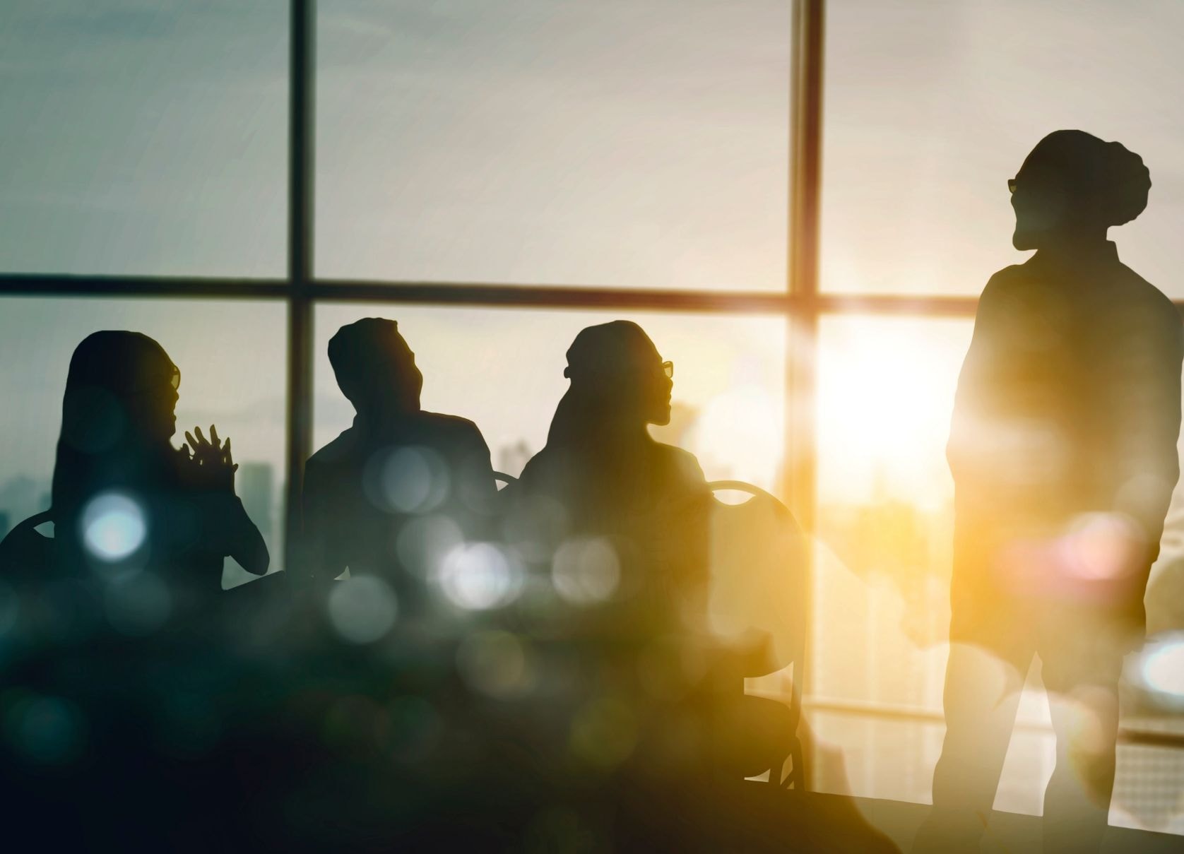 Silhouettes of people in a meeting room